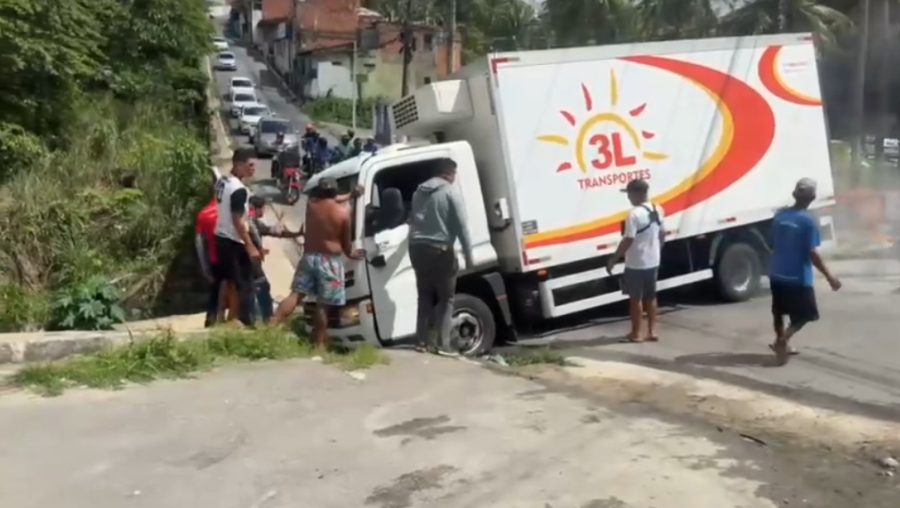 Caminhão fica preso em buraco de esgoto e bloqueia trânsito na Ladeira da Moenda, em Maceió